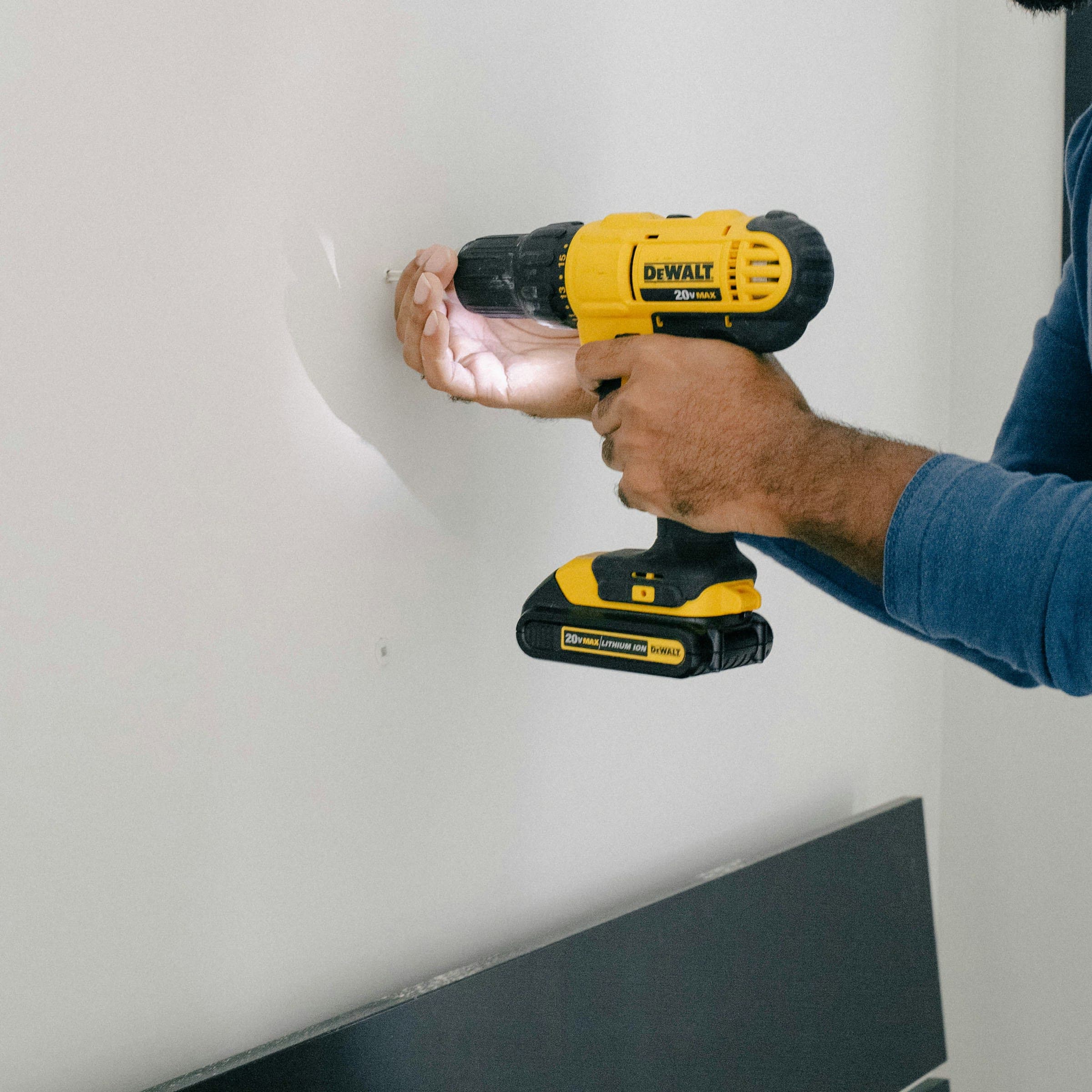 Drilling into a wall with a cordless drill