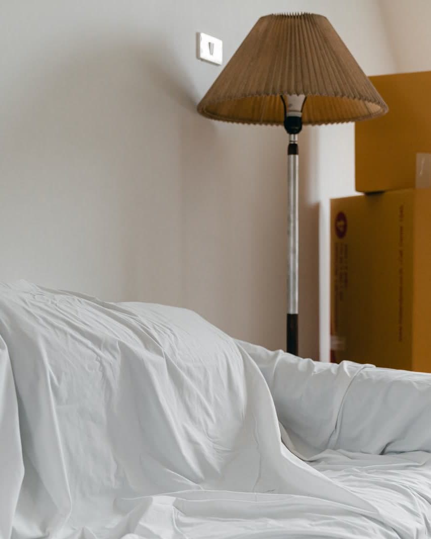 A covered sofa and packed boxes in a room ready for a move